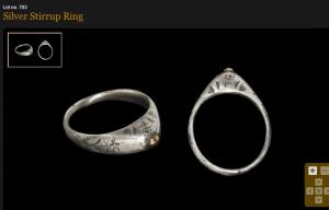 Circa 13th century AD. A silver stirrup ring with engraved foliage motifs on the hoop and shoulders, surmounted by a domed gold stud..jpg